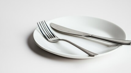Empty white plate with fork and knife on white background, ready for meal, tableware