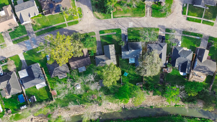 Residential houses along Cole Creek grass-lined channel in Fairbanks Northwest Crossing neighborhood, Harris County, greater Houston area, early morning spring, suburban detached homes, aerial