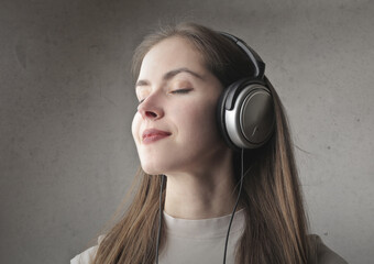 young woman listens music with earphone