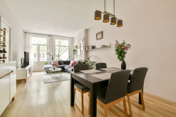 Stylish modern living room featuring a dining area, bright natural light, and decorative plants, creating a warm and inviting atmosphere.