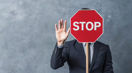 Businessman holding stop sign blocking face with raised hand gesture