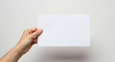 Fototapeta premium Blank sheet of paper held by a hand.