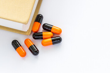 A book with a stack of pills on top of it