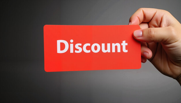 Hand holding a discount card against a dark background  