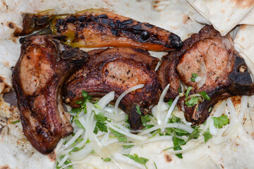 Grilled meat. Pork barbecue. Fried meat with onions, potatoes wrapped in pita bread. Lamb steak on pita bread with grilled potatoes on wooden table. Restaurant food. Fast food