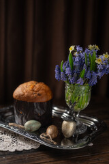 Traditional Easter Cake and White Eggs with Gold Leaf on Rustic Table with Spring Flowers