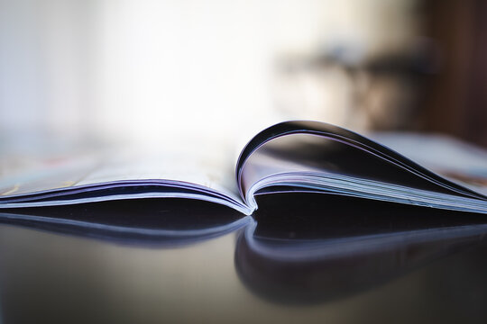 Close up details of open magazine on coffee table with copy space