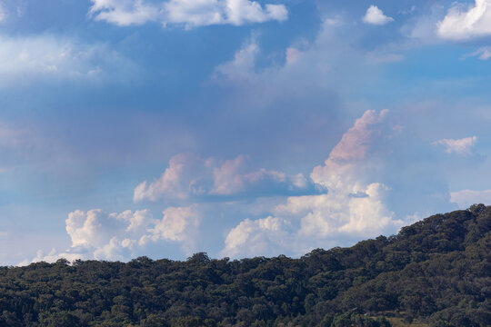 Bushfire smoke merging with fluffy white clouds in the distance