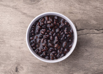 Cooked black beans in a bowl over wooden table