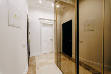 There is a hallway featuring a mirrored wardrobe along with a door
