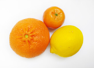 Vibrant citrus fruits - orange, mandarin, and lemon - arranged on a pristine white background.  A...