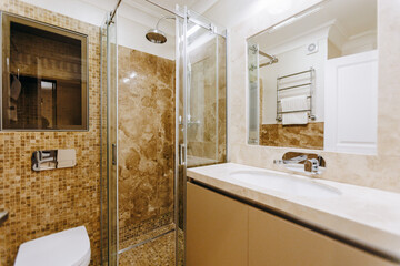 A wellequipped bathroom featuring a toilet, sink, shower, and mirror