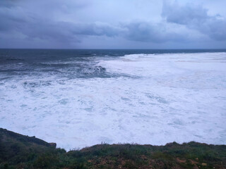 Dramatic seascape with powerful waves crashing under a stormy sky. Evokes themes of natures force, resilience, or environmental challenges. Perfect for backgrounds or editorials.