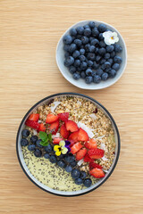 Healthy breakfast avocado smoothie bowl with fresh fruits and chia seeds on wooden table