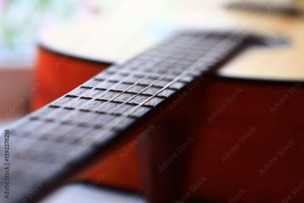 Poster a detailed view of a guitar with a blurred background.