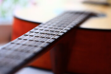 A detailed view of a guitar with a blurred background.