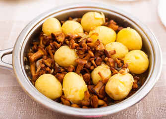 Delicious fried chanterelles with new potatoes in a frying pan