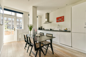 Bright and airy modern kitchen featuring a dining table, stylish decor, and large windows for natural light. A perfect blend of functionality and aesthetics.