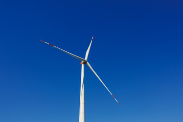 Wind turbines generating energy against a clear blue sky. Wind turbines generating clean renewable...