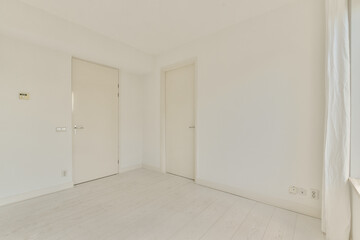 A simplistic interior featuring white walls and doors, showcasing a clean and minimalist design ideal for modern aesthetics and tranquil living spaces.