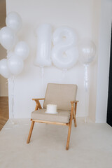 Little cute boy with white balloons celebrating 18 months.