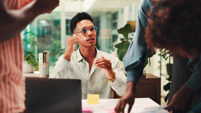 Businessman, discussion and laptop with team for collaboration, explanation or planning at office. Male person, conversation or explaining tasks with colleagues or group for project agenda or design