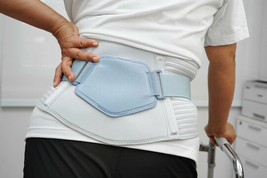 Asian woman wearing lumbar support pain back and use walker in hospital.