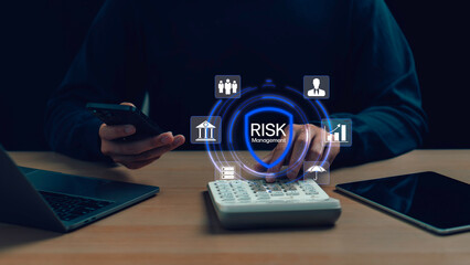 Businessman using mobile and calculator with virtual risk management icon, representing financial planning, data protection, and strategic business decisions in a digital environment.