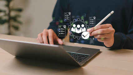 Businessman using laptop and stylus with digital HR icon for employee management, recruitment...
