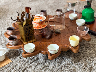 Vintage ceramic teapot and cups on linen with eucalyptus and moonstone jewelry. Tea ceremony and sensory aesthetics