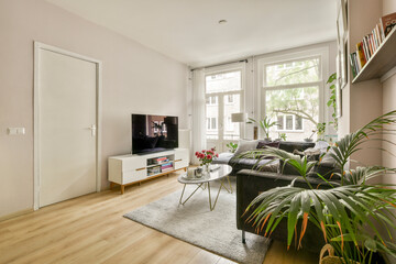 A bright and stylish living room showcasing modern furniture, indoor plants, and natural light enhancing the cozy ambiance.
