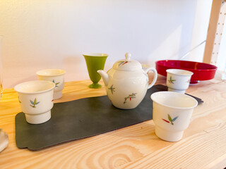 Porcelain teapot and cups arranged on wooden table. Mindfulness, ritual and harmony in the context of traditional tea ceremony
