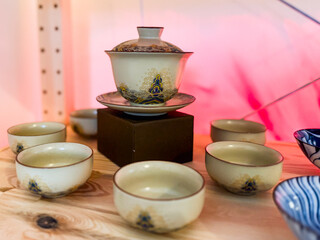 Traditional gaiwan with matching tea cups arranged on wooden surface. Harmony, ritual and elegance in Chinese tea ceremony