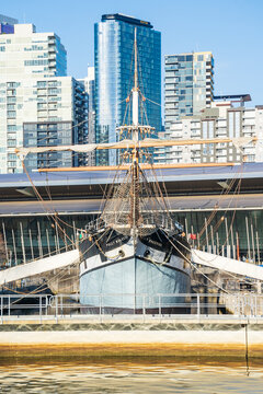 A front on view of the tall ship "Polly Woodside" docked in front of city buildings
