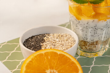 Close-up of chia seeds and oatmeal flakes, orange on a yogurt background. Healthy eating. Diet. Top view.