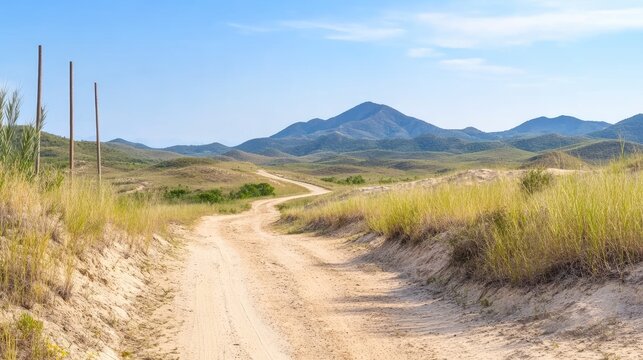 Serene landscape of a winding dirt road through arid hills and distant mountains