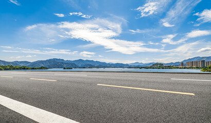 Fototapeta premium Empty asphalt road with mountain and lake landscape on sunny day. Transportation background.