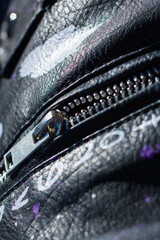 Close up of a zipper on a stylish black leather jacket