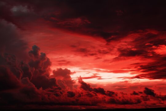 Dramatic red sky with dark clouds at sunset creates a fiery and ominous landscape