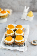 Lemon cupcakes with cream cheese, apricot and poppy seed. Cupcake in form of Fried Egg on a stone background. Easter eggs. Easter holiday and festive food.