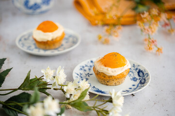 Lemon cupcakes with cream cheese, apricot and poppy seed. Cupcake in form of Fried Egg on a stone background. Easter eggs. Easter holiday and festive food.