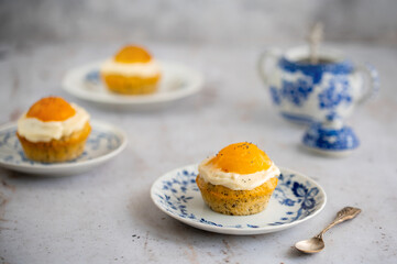 Lemon cupcakes with cream cheese, apricot and poppy seed. Cupcake in form of Fried Egg on a stone background. Easter eggs. Easter holiday and festive food.