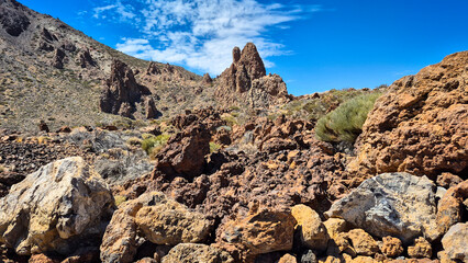 Impressive volcanic landscape with solidified lava rocks and sparse vegetation, creating a unique...