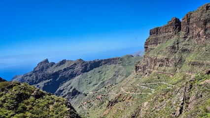 Breathtaking landscape of masca valley in tenerife, canary islands, featuring a winding road amidst steep cliffs and lush greenery