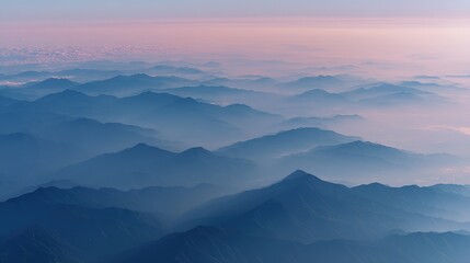 Fototapeta premium Aerial view of the foggy mountains at sunrise. The panorama of cascading mountains and a sea of clouds in the Chinese art style is reminiscent of National Park Award winning photographs.