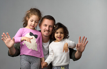 Happy Father and Two Daughters Waving Hands