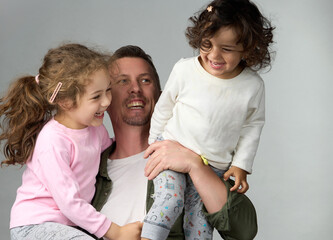 Happy Father with Daughters. Smiling father holding his two laughing daughters his arms