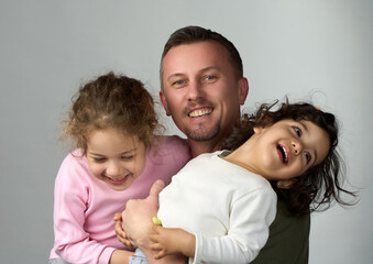 Happy Father with Daughters. Smiling father holding his two laughing daughters his arms