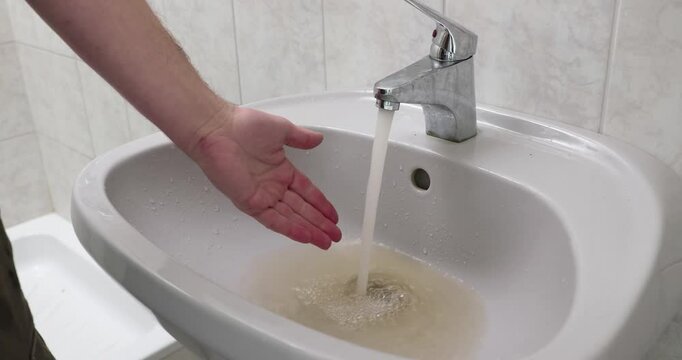 Dirty tap water flowing, dark sediments