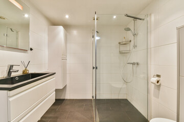 Well-designed bathroom featuring a spacious glass shower, sleek vanity, and contemporary tile flooring, blending functionality with modern aesthetics.
